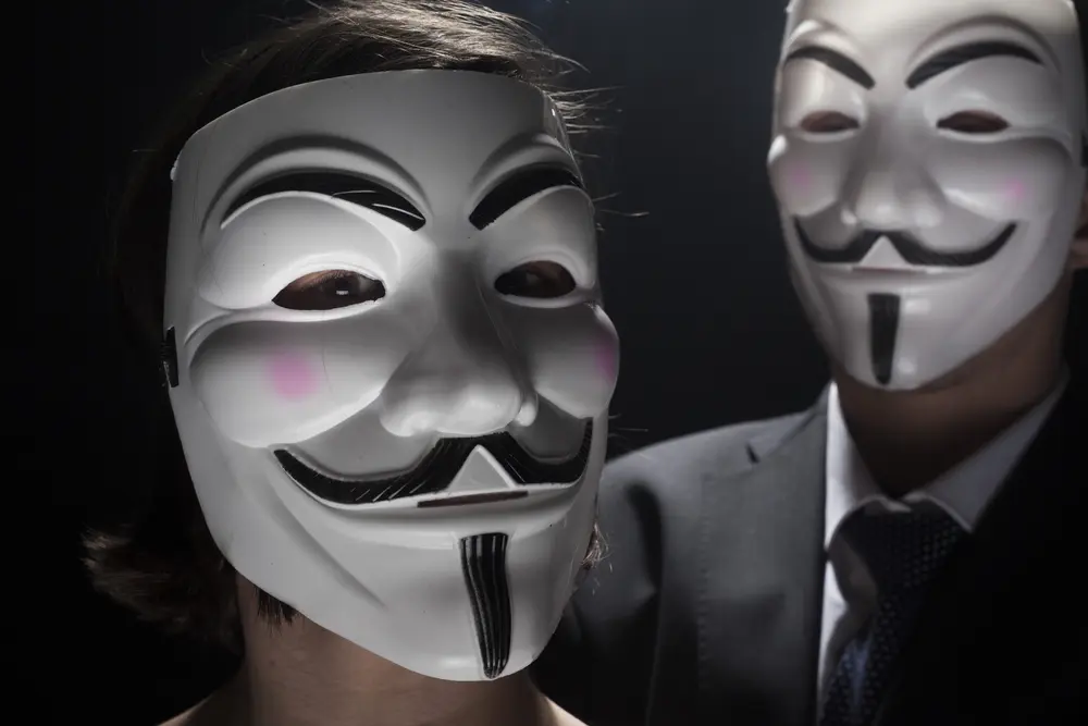 prague march 6: two members of anonymous activist hacker group with mask studio shot
